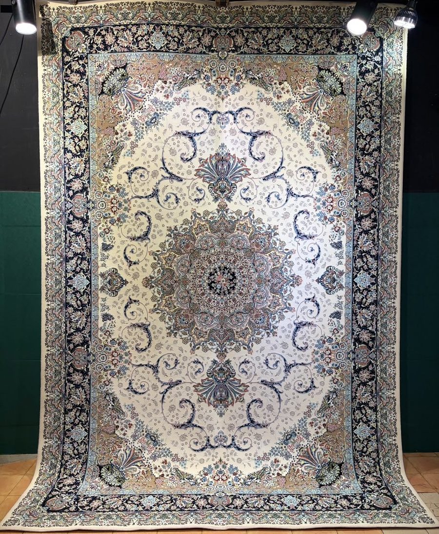 Machine-made carpet, ivory field with navy scrollwork medallion and floral corners