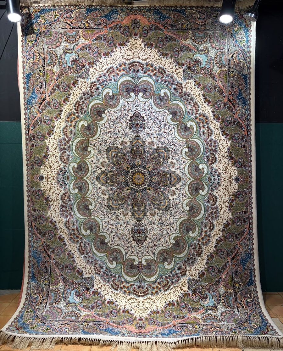 Machine-made carpet, cream field with sage green oval medallion and floral corners